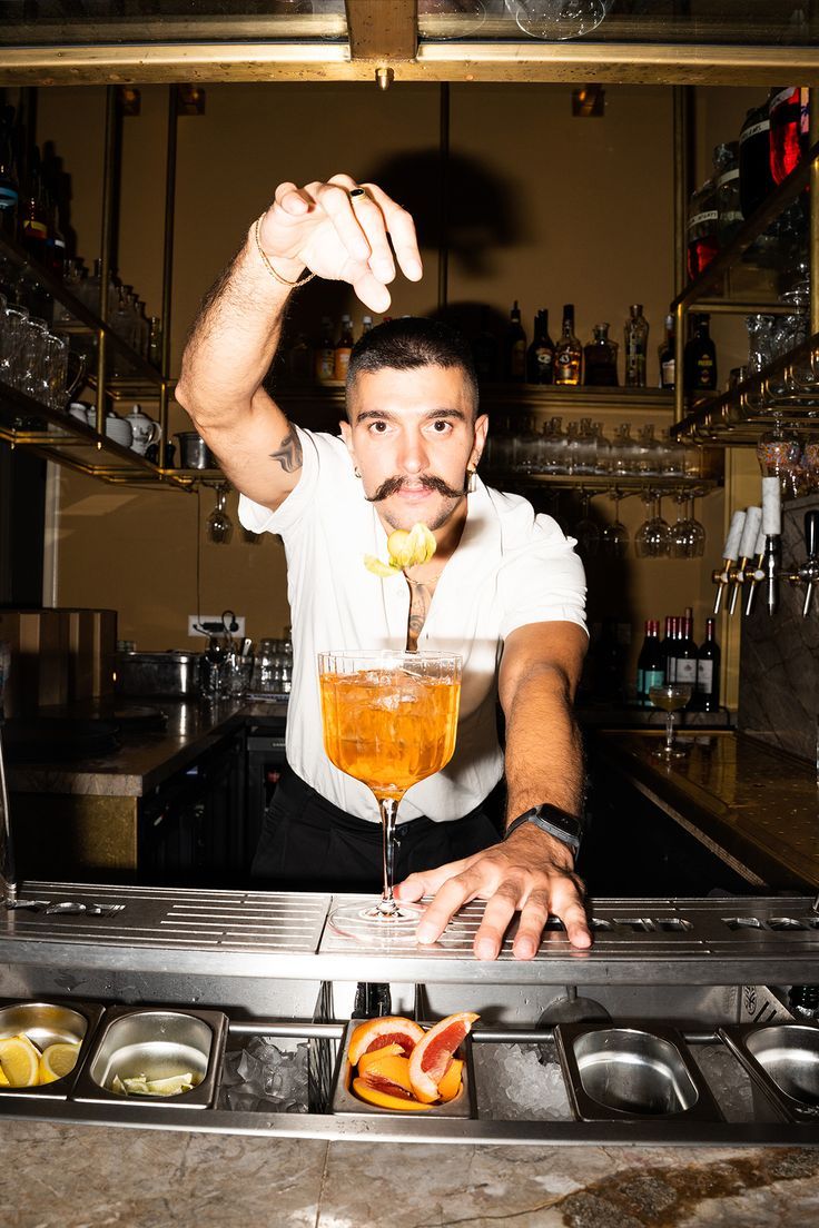 Barman werkt aan een cocktail achter de bar